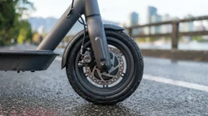A high-detail view of the front mechanical disc brake system on a single motor electric scooter.