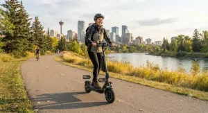 A rider enjoying a long-range electric scooter on a paved multi-use trail in Calgary, showcasing extended battery life for longer recreational rides.