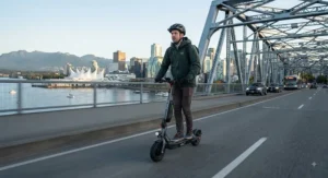 A person using a portable fast charger for their electric scooter in a Vancouver park