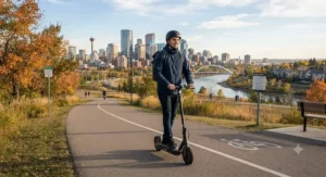 A commuter riding a mid-speed electric scooter for commuting along a scenic paved pathway overlooking Calgary.