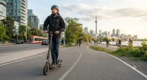 A commuter riding a fast electric scooter on a paved urban bike path in Toronto.