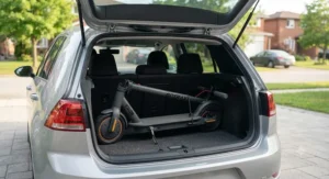 An affordable electric scooter safely placed inside the trunk of a hatchback car.