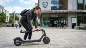 A student folding up speed limited electric scooters under $700 CAD outside an Ottawa campus building